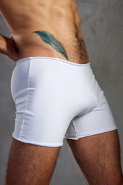 Closeup of man wearing tight white boxer briefs, featuring feather tattoo on hip