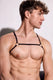 Fit man wearing black minimalist harness, showing muscular torso, trendy men's fashion
