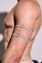 Male model in minimal grey harness arm straps, showing athletic physique.