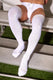 Man wearing white lace-up jockstrap and thigh-high socks on stadium bench