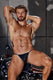 Muscular man in black leather thong underwear posing on motorcycle against concrete wall