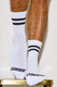 White athletic socks with black stripes and Coyote text, worn on hairy male legs