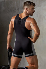 Athletic man in black and grey sports singlet, holding gym bag, facing away in studio