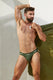 Athletic man modeling green jockstrap underwear with logo waistband against a minimalist wall