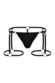 Jet black men's garter thong with metal ring hardware and strappy detailing on white background