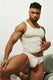 Man wearing beige ribbed tank top and matching briefs with white waistband, posing indoors