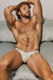 Male model reclining on a bed wearing beige men's briefs with visible logo waistband.